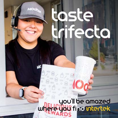 A restaurant employee handing bagged food out of a drive-up window