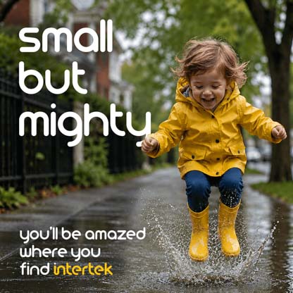 A young child jumping in a puddle while wearing rain-proof attire